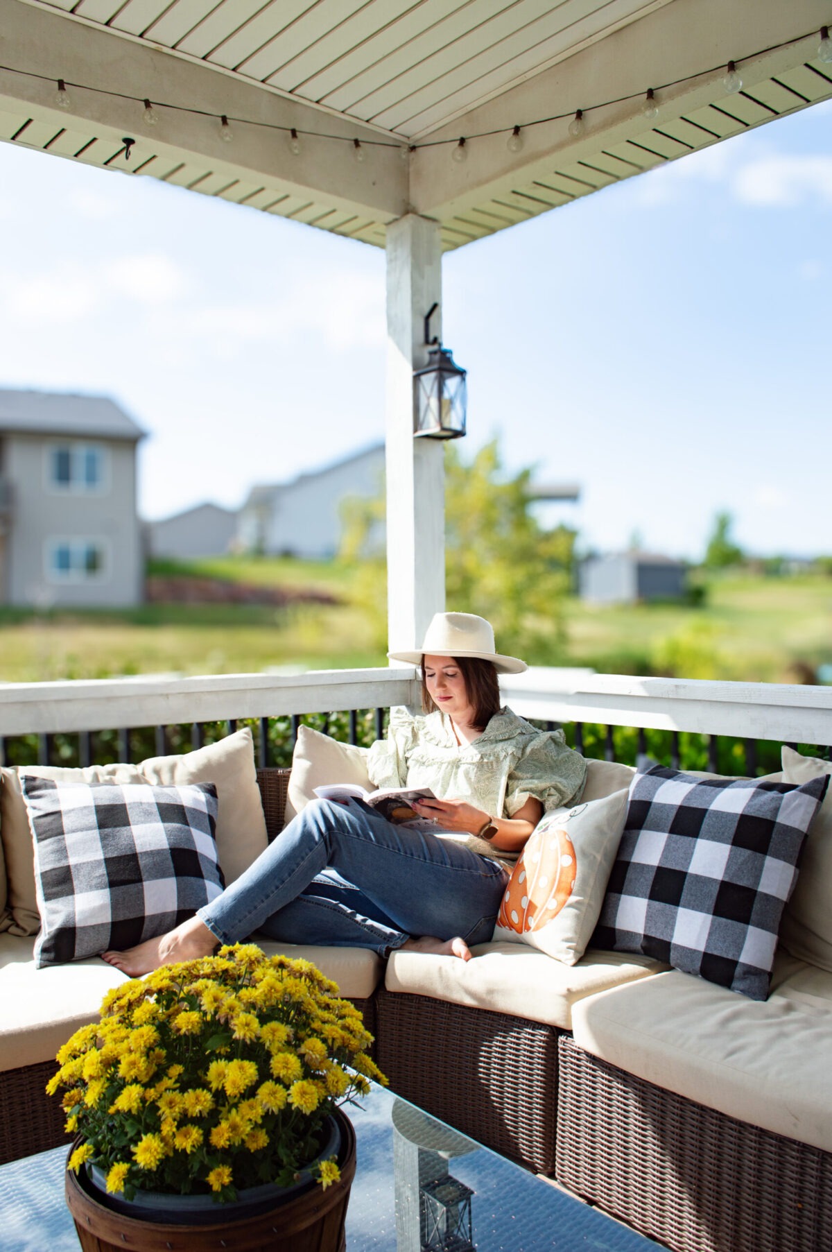 woman reading a book in the sunshine on the deck